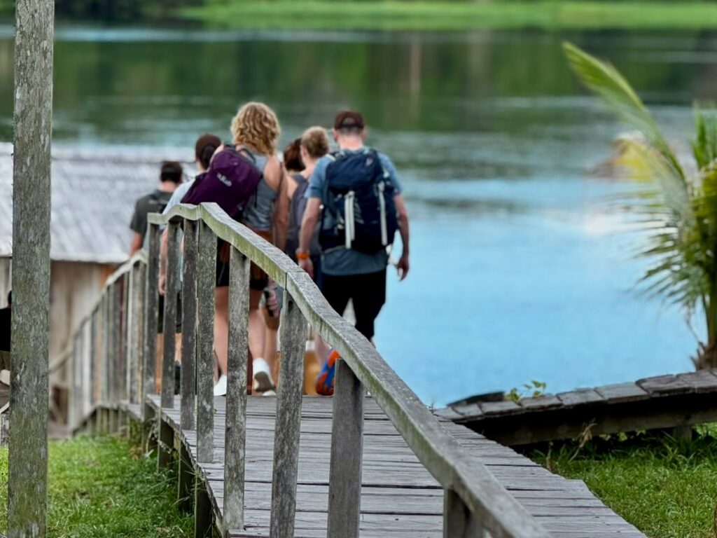 Guests walking the lodge boardwalk toward the lake